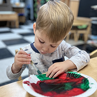 child painting on paper plate